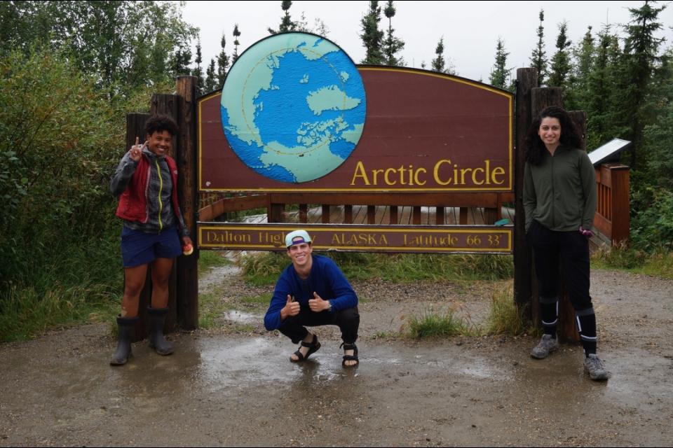 Three department members standing in front of an &quot;Arctic Circle&quot; sign
