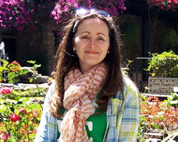 Nuala Cowan smiling in front of flowers