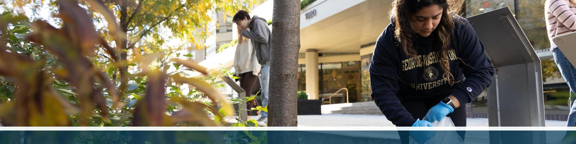 A geography student in a fieldwork location near GW's campus, wearing a GW sweatshirt
